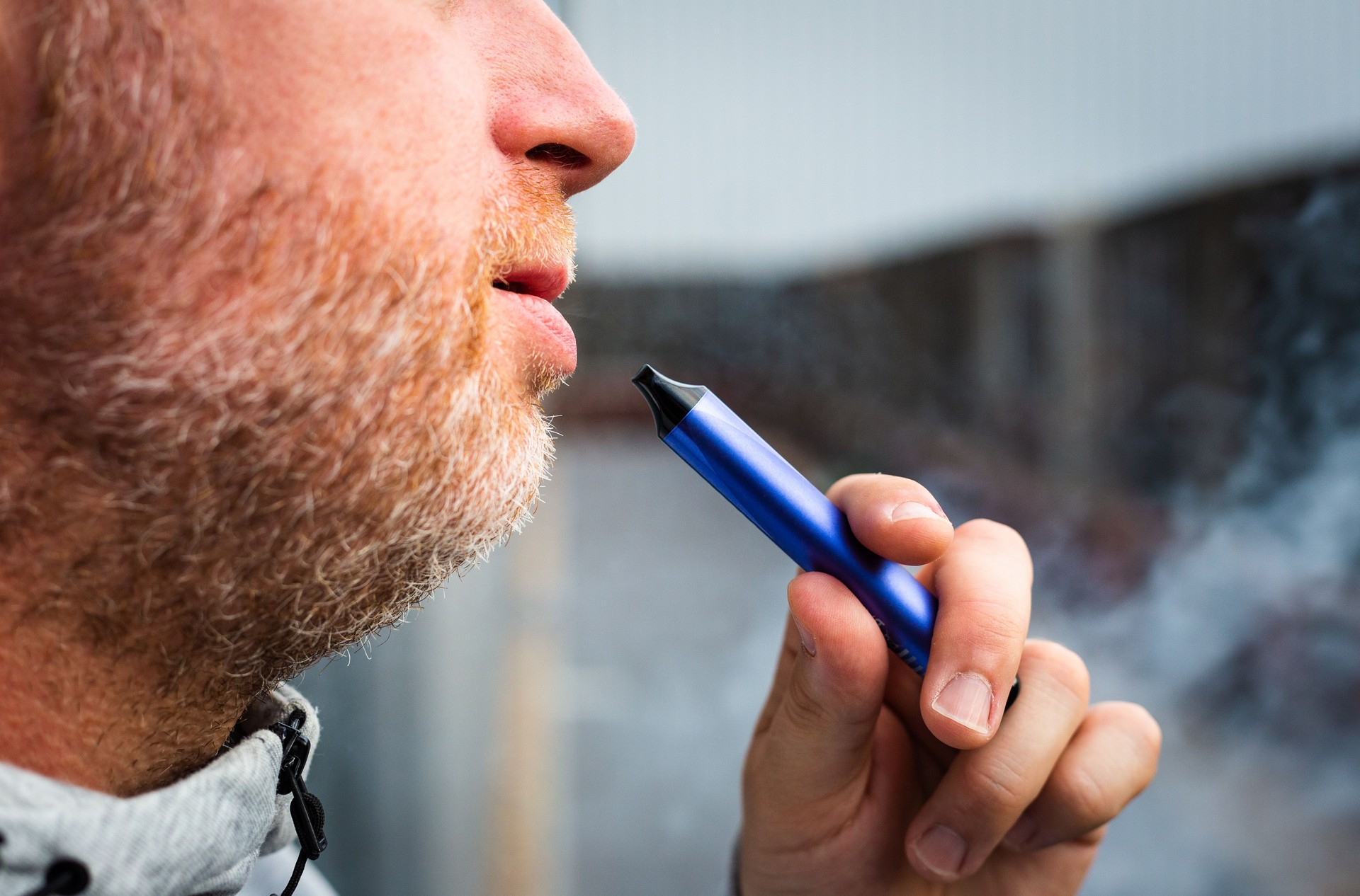 Man vaping using disposable vape outdoors
