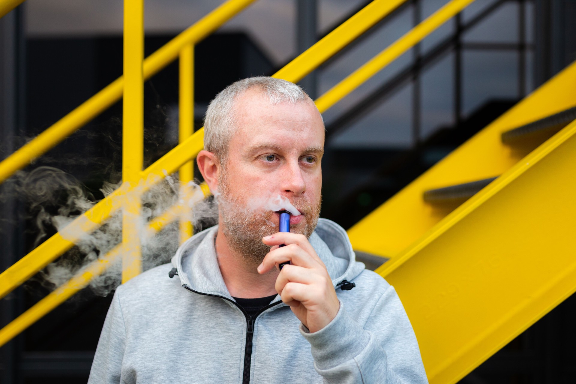 Man vaping using disposable vape outdoors